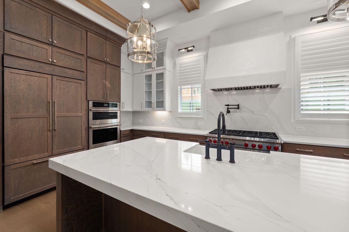 Finished kitchen with refined wood cabinetry and marble surfaces